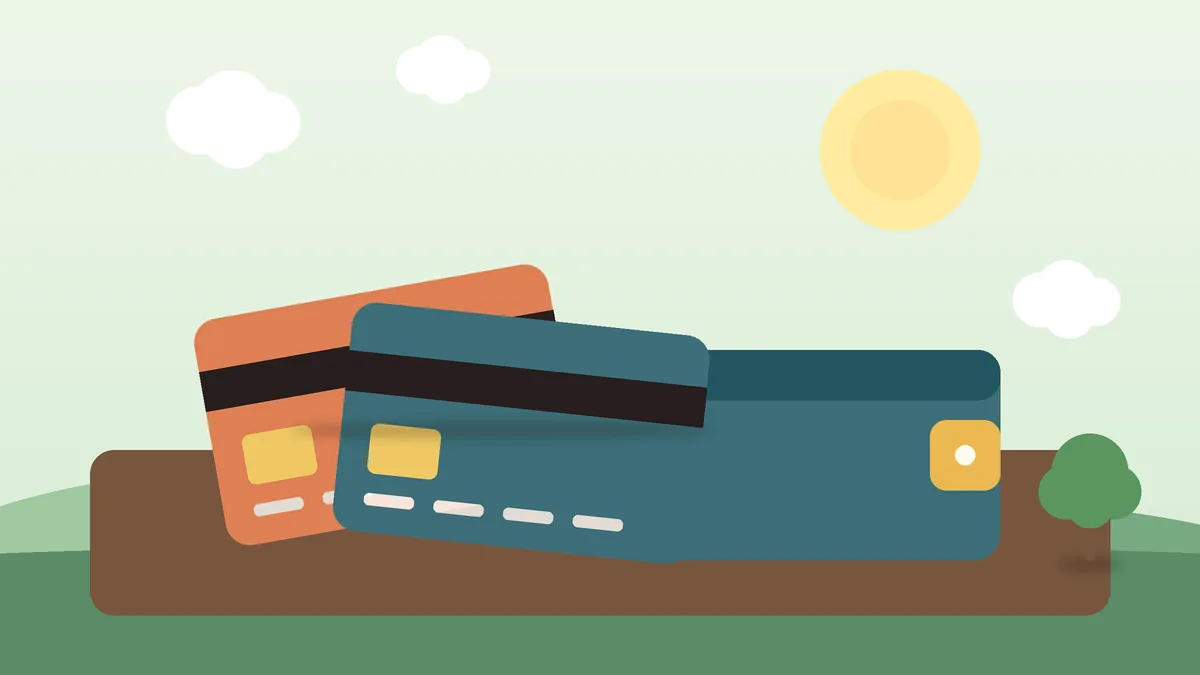 Cartão de crédito e moedas, ilustrando a dívida do cartão e o rotativo